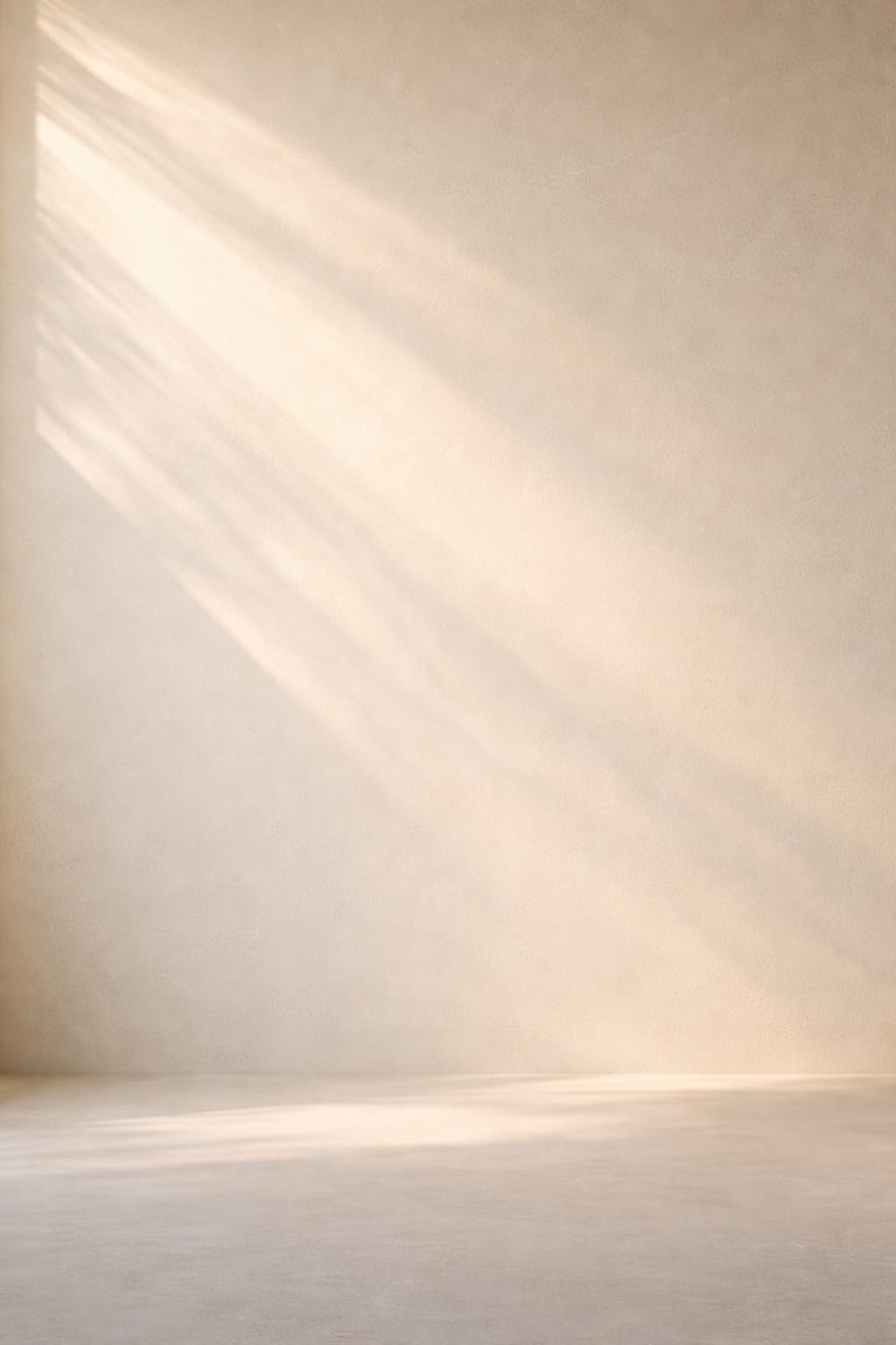 aevora-gradual-renewal-mineral-wall-vertical Soft natural light moving across a smooth warm ivory mineral wall, representing gradual renewal over time.