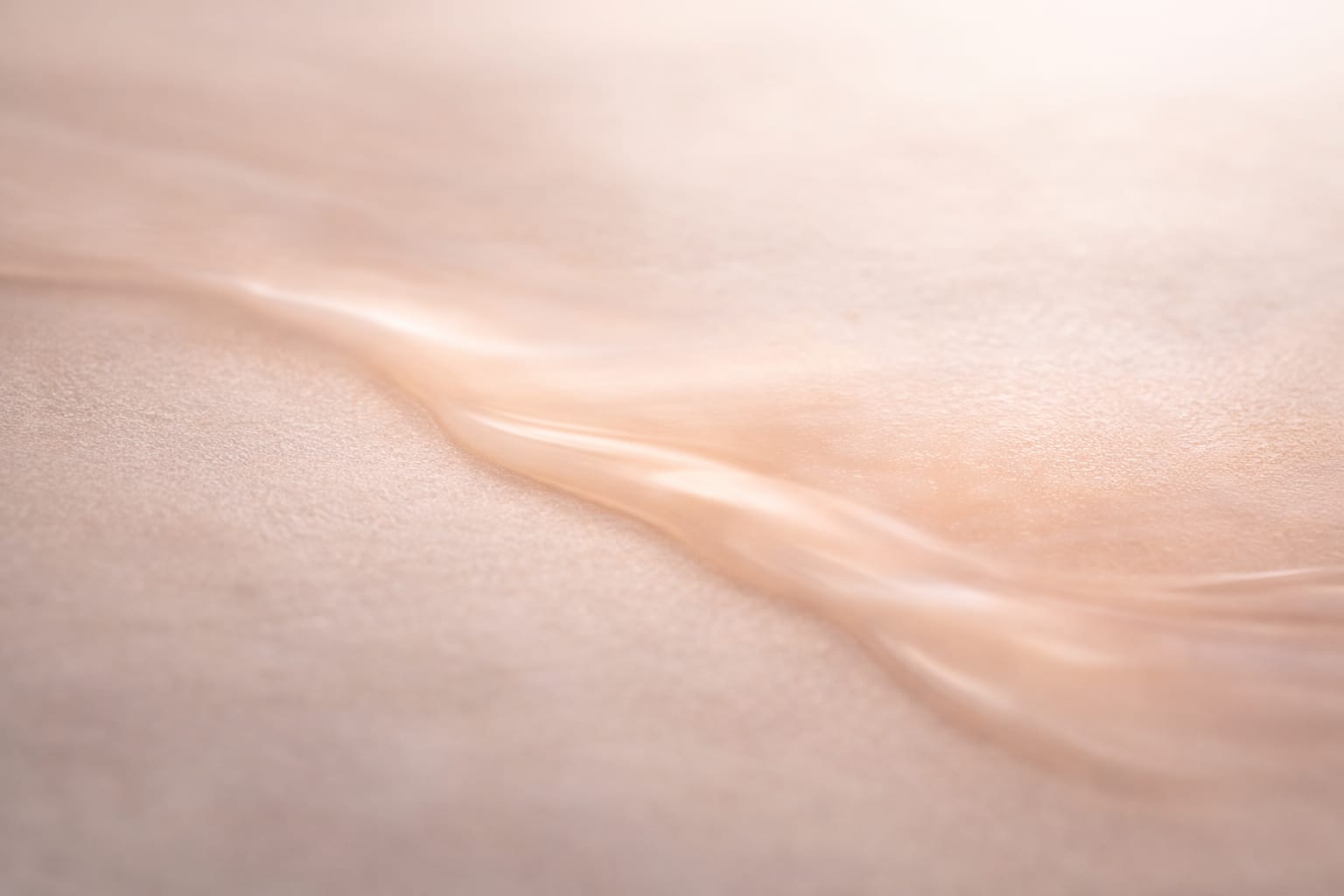 Close-up of a body cream spreading evenly across a smooth surface, representing consistent delivery and controlled application.